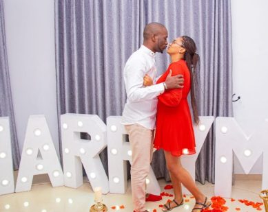 Couple posing with Marry Me balloons